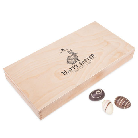 Coffret en bois claire plein de chocolats de Pâques