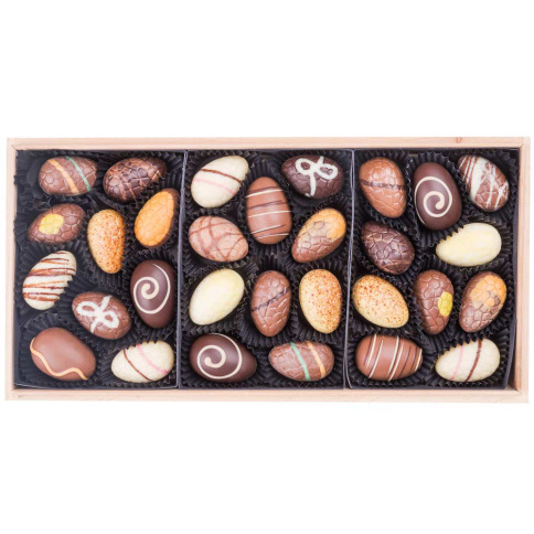 Coffret en bois claire plein de chocolats de Pâques